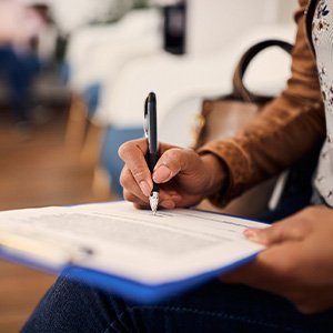 a woman filling out forms on a clipboard