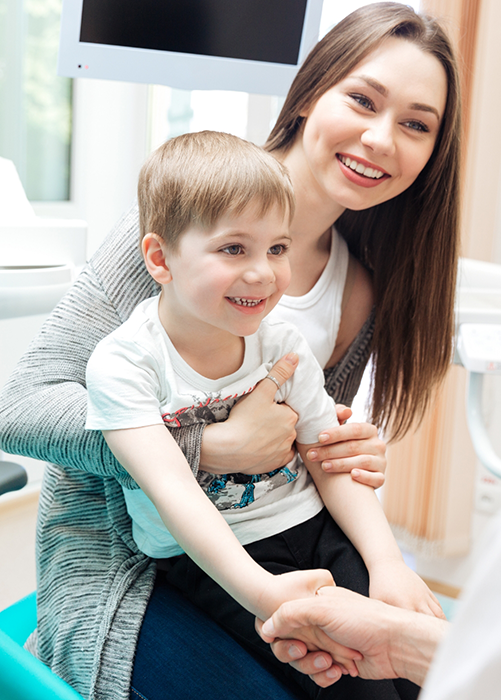 Mother holding her child while visiting children's dentist in Plano