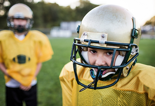 Little boy wearing a football helmet