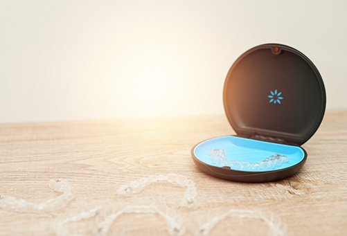 Clear aligners around storage case on wooden table