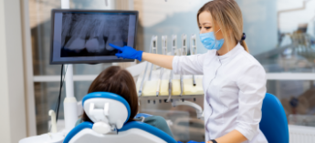 Woman pointing to image of teeth on chairside monitor