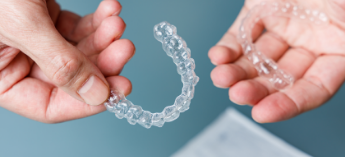 Hands holding clear aligners