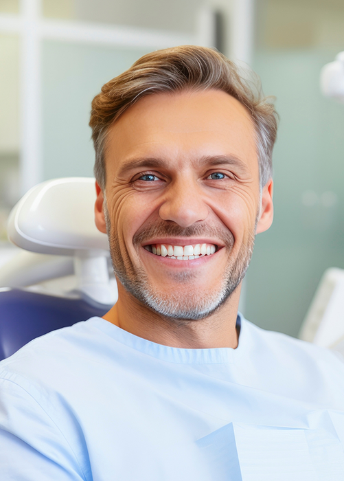 Bearded man in dental chair smiling