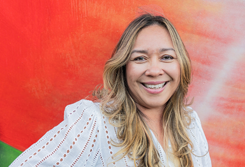 Smiling woman in front of large red wall painting