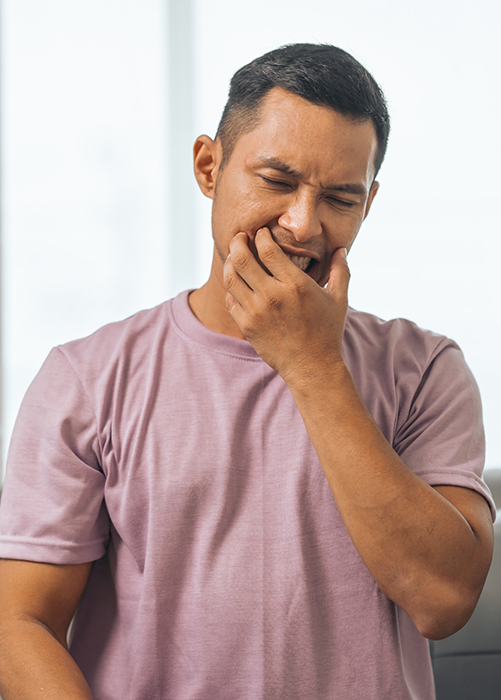 Man in light purple shirt with jaw pain