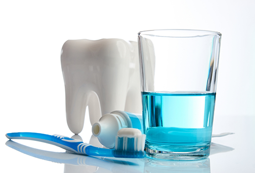 Tooth, toothbrush, toothpaste, and cup of mouth rinse