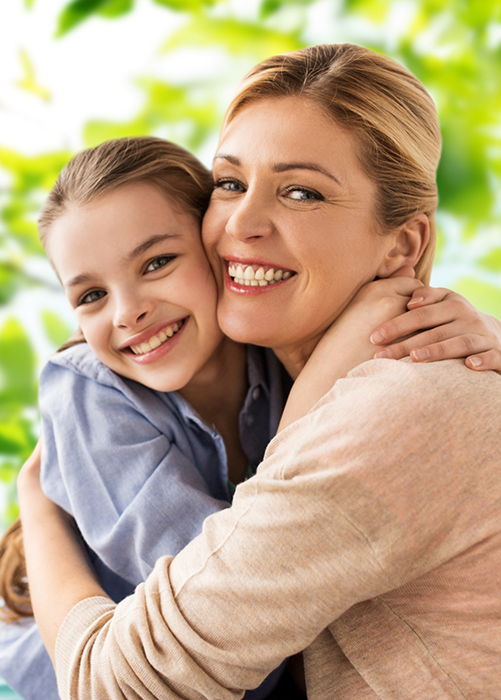 Mother hugging daughter from side