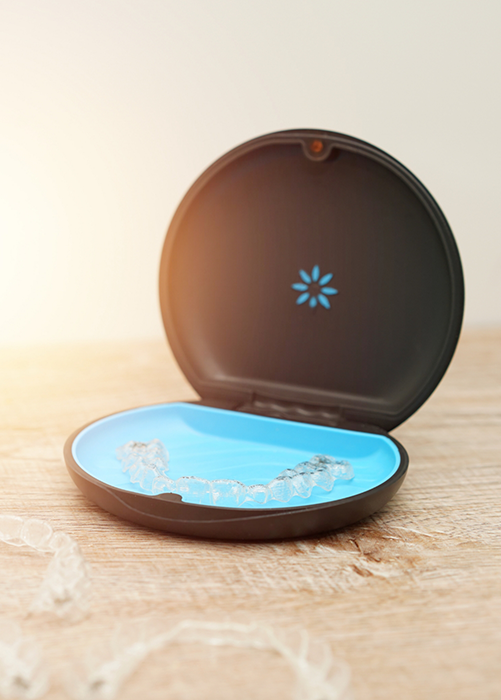 Invisalign clear aligners in Plano around a storage case