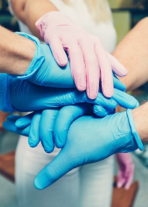 Dental team members putting their gloved hands together