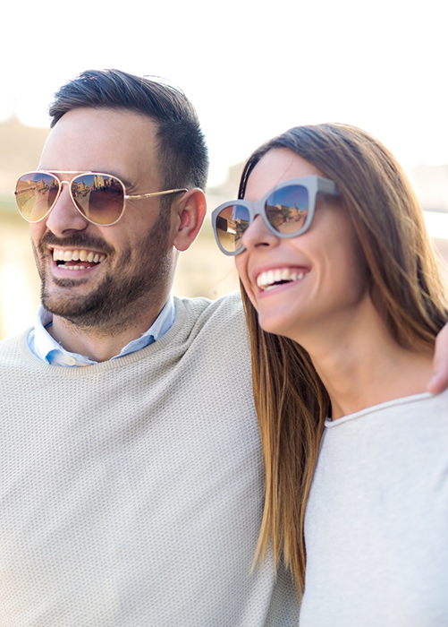 Man and woman with sunglasses smiling
