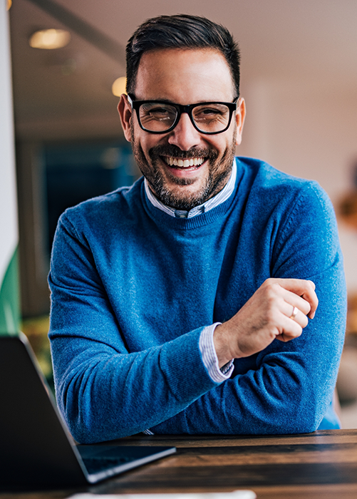 Smiling man with glasses and blue sweater