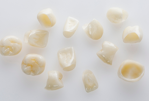 Multiple dental crowns on a white surface